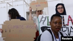 Members of the International Federation of Medical Students Associations hold placards during a protest demanding an end to fossil fuels at COP28 World Climate Summit, in Dubai, United Arab Emirates, Dec. 3, 2023.