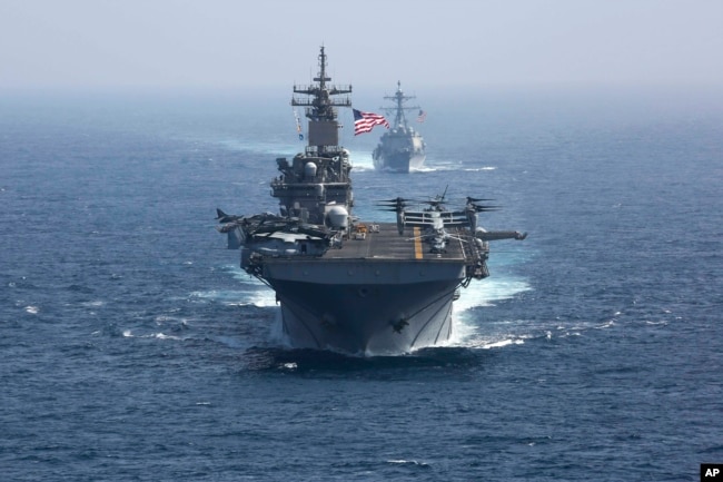 FILE - The amphibious assault ship USS Kearsarge and the Arleigh Burke-class guided-missile destroyer USS Bainbridge sail in formation as part of the USS Abraham Lincoln aircraft carrier strike group in the Arabian Sea. President Joe Biden has chosen Adm. Lisa Franchetti to lead the Navy, a senior administration official said July 21, 2023. (U.S. Navy via AP)