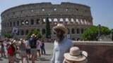 FILE - A street vendor sells hats in front of the Colosseum in Rome, Monday, July 17, 2023. (AP Photo/Gregorio Borgia)