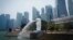 FILE - The Merlion statue spouts water at a park with the background of a business district in Singapore, Sept, 21, 2019. 