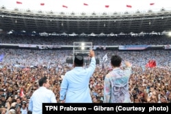 Pasangan capres dan cawapres Prabowo Subianto dan Gibran Rakabuming Raka menyapa para pendukungnya dari atas panggung dalam kampanye akbar di Stadion Gelora Bung Karno, Jakarta, Sabtu, 10 Februari 2024. (Foto: TPN Prabowo – Gibran)