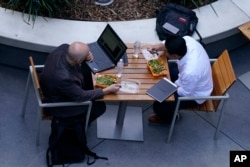 People work over lunch downtown Los Angeles on Tuesday, March 15, 2022.