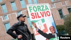 A supporter of former Italian Prime Minister Silvio Berlusconi stands near the hospital where Berlusconi is hospitalized, in Milan, Italy, April 7, 2023. 