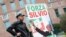 A supporter of former Italian Prime Minister Silvio Berlusconi stands near the hospital where Berlusconi is hospitalized, in Milan, Italy, April 7, 2023. 