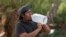 Brad Pablo drinks water while fishing at Christopher Columbus Park during a heat wave in Tucson, Arizona, on July 15, 2023.