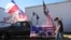 A participant passes flags and signage during a 'Take Our Border Back' rally, Feb. 3, 2024, in Quemado, Texas.