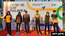 Baju-baju yang akan dikenakan oleh para atlet Malaysia di Olimpiade Paris, dipamerkan dalam sebuah acara di Kuala Lumpur, 23 Juni 2024. Baju kontingen Malaysia itu mendapat kecaman para fans. (Foto: AFP)
