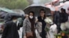 FILE - Iranian women walk through rain in a flower market, ahead of Nowruz, the Iranian New Year, in Tehran, Iran March 16, 2023.