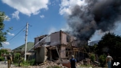 乌克兰消防员正在南部赫尔松地区为一栋被俄罗斯炮击摧毁的民房灭火。（2023年7月1日）