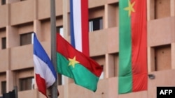 FILE - A French flag flies next to a Burkina Faso flag in Ouagadougou, Nov. 27, 2017. The African country has expelled three French diplomats, a government statement announced April 18, 2024.