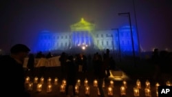 La gente enciende velas a medianoche alrededor del Palacio Legislativo en el 50 aniversario del golpe militar de 1973, en Montevideo, Uruguay, el martes 27 de junio de 2023. (Foto AP/Matilde Campodonico)