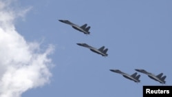 FILE - J-11B fighter jets of the Chinese Air Force fly during a training session on the outskirts of Beijing, July 2, 2015. China's air force and navy staged another large-scale drill involving fighters, bombers and warships to Taiwan's south and southwest on Tuesday.