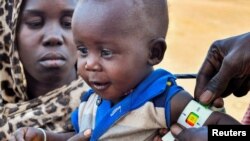 FILE- A child is examined for malnutrition in Renk County, Upper Nile state, South Sudan April 30, 2023. REUTERS/Jok Solomun REFILE - QUALITY REPEAT TPX IMAGES OF THE DAY.