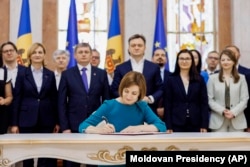In this image released by Moldova's President, Moldova's President Maia Sandu signs the decree on initiating Moldova's EU accession negotiations in Chisinau, Moldova, June 21, 2024. (Moldovan Presidency via AP)