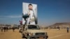 Houthi fighters display a poster of the leader of the Houthi movement, Abdel Malek al-Houthi, during a rally in support of the Palestinians in the Gaza Strip and against the US-led airstrikes on Yemen, in Sanaa, Yemen, Jan. 29, 2024.