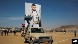 Houthi fighters display a poster of the leader of the Houthi movement, Abdel Malek al-Houthi, during a rally in support of the Palestinians in the Gaza Strip and against the US-led airstrikes on Yemen, in Sanaa, Yemen, Jan. 29, 2024.