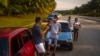 Un conductor bebe un refresco mientras espera que llegue un camión cisterna con combustible, en La Habana, Cuba, el viernes 14 de abril de 2023. (Foto AP/ Ramón Espinosa)