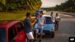 Un conductor bebe un refresco mientras espera que llegue un camión cisterna con combustible, en La Habana, Cuba, el viernes 14 de abril de 2023. (Foto AP/ Ramón Espinosa)