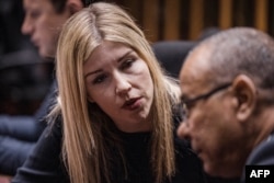 FILE - Legal journalist Karyn Maughan speaks with a member of her legal team at the High Court in Pietermaritzburg, South Africa, on Oct. 10, 2022.