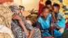 Une femme et des enfants assis avec d'autres personnes déplacées, Soudan le 12 septembre 2023. 