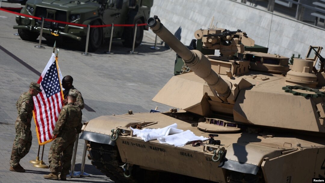 Tentara AS tampak berada di dekat tank M1 Abrams yang diparkir di luar aula pada ajang Ekshibisi Industri Pertahanan Internasional di Kielce, Polandia, pada 5 September 2022. (Foto: Reuters/Kacper Pempel)
