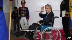 ARCHIVO: El presidente de Ecuador, Guillermo Lasso, en silla de ruedas, saluda a la prensa en el palacio de gobierno el lunes 6 de marzo de 2023. 