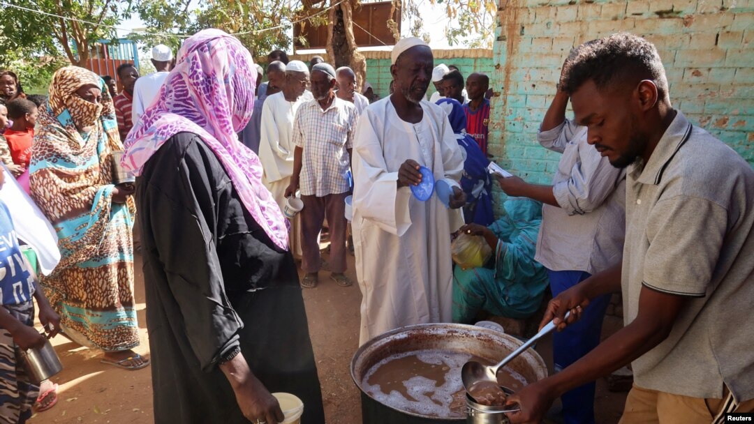 Voluntários distribuem alimentos a residentes e pessoas deslocadas em Omdurman, Sudão, 8 de março de 2024.