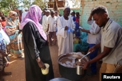 FILE - Volunteers distribute food to residents and displaced people in Omdurman, Sudan, March 8, 2024.