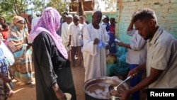 Voluntários distribuem alimentos a residentes e pessoas deslocadas em Omdurman, Sudão, 8 de março de 2024.