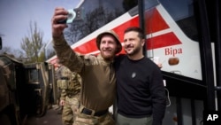 In this photo provided by the Ukrainian Presidential Press Office, Ukrainian president Volodymyr Zelenskyy poses for a selfie with a soldier at a position in Avdiivka, Donetsk region, Ukraine, April 18, 2023. 