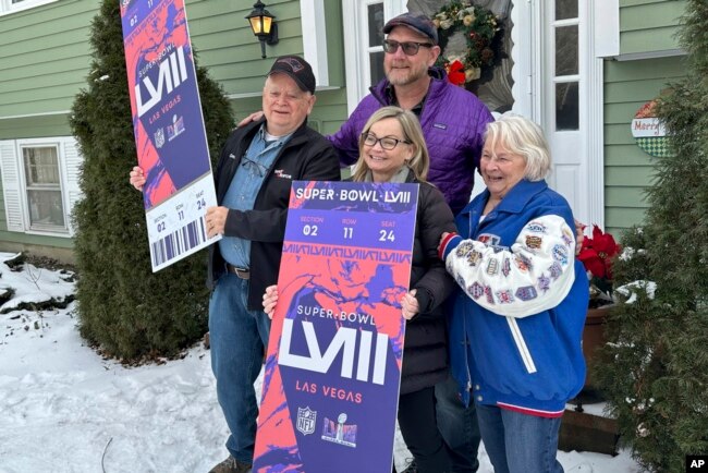 Don Crisman, far left, poses with his wife, Beverley, far right, his daughter Sue Metevier, and her partner Charles Hugo, with posters of Super Bowl 58 tickets, in Kennebunk, Maine, Jan. 18, 2024.
