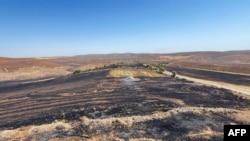 This handout photograph taken and released on June 21, 2024, by Turkish news agency DHA (Demiroren News Agency) shows a burnt field after a wildfire swept overnight through two areas between the cities of Diyarbakir and Mardin in southeastern Turkey.