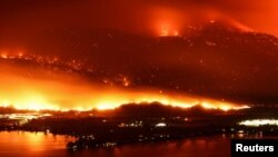 Kebakaran hutan Eagle Bluffs merembet ke perbatasan negara bagian Washington di AS dan memicu pengumuman perintah evakuasi di Osoyoos, British Columbia, Kanada, Minggu, 30 Juli 2023. (Foto: Jesse Winter/Reuters)