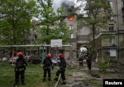 Firefighters work at a site of an apartment building hit by a Russian missile strike, amid Russia's attack on Ukraine, in Dnipro, Ukraine, April 19, 2024.
