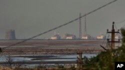 FILE - The Zaporizhzhia nuclear power plant, Europe's largest, is seen in the background of the shallow Kakhovka Reservoir after the dam collapse, in Energodar, Russian-occupied Ukraine, June 27, 2023.