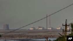 FILE - The Zaporizhzhia nuclear power plant, Europe's largest, is seen in the background of the shallow Kakhovka Reservoir after the dam collapse, in Energodar, Russian-occupied Ukraine, June 27, 2023.