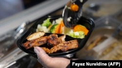 Seorang staf restoran menyiapkan makanan diet untuk seorang pelanggan di Riyadh pada 12 Februari 2023. (Foto: Fayez Nureldine/AFP)