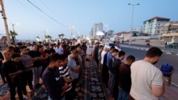 Warga Palestina melakukan salat berjemaah di sepanjang jalan pesisir di Kota Gaza 29 Mei 2023. REUTERS/Mohammed Salem