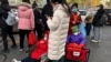 北京一家儿童医院外排队等候看病的儿童和家长。（2023年11月27日）