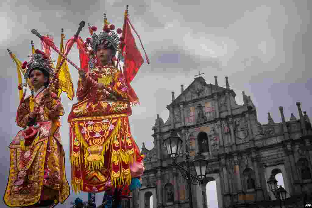 Children dressed as deities take part in a procession in front of the Ruins of St. Paul during celebrations marking the Feast of Na Tcha in Macau, China.