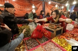 People shop for the upcoming Lunar New Year celebrations at the Dihua street market in Taipei, Taiwan, Thursday, Feb. 8, 2024. (AP Photo/Chiang Ying-ying)