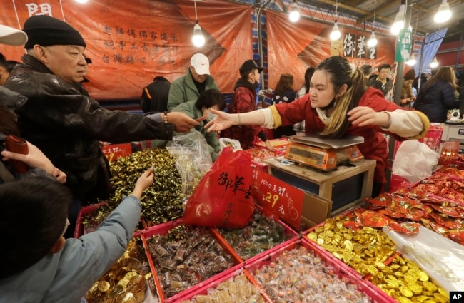 People shop for the upcoming Lunar New Year celebrations at the Dihua street market in Taipei, Taiwan, Thursday, Feb. 8, 2024. (AP Photo/Chiang Ying-ying)