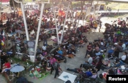 Migrants traveling in a caravan rest in a public square before continuing their journey through Mexico, in Huixtla, Mexico, Dec. 25, 2023.