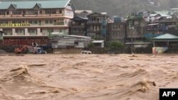 Kendaraan terendam banjir saat air naik di sepanjang Sungai Chico di Bontoc, Provinsi Pegunungan saat Topan Super Doksuri melintas di dekat ujung utara Pulau Luzon. (Foto: Handout / Kantor Manajemen Pengurangan Risiko Bencana Provinsi Pegunungan (DRRMO)/ AFP)