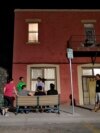 FILE - Migrants socialize outside Annunciation House, June 26, 2018, in El Paso, Texas. A Texas judge ruled against the state attorney general on July 2, 2024, in his effort to shut down a the shelter, which he claimed encourages illegal migration.