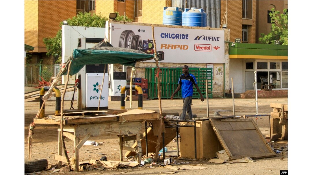 A man walks past an abandoned stall near a petrol station in the south of Khartoum on April 17, 2023.