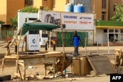 A man walks past an abandoned stall near a petrol station in the south of Khartoum on April 17, 2023.