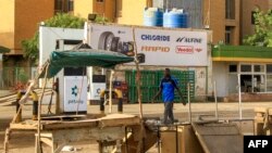 FILE: A man walks past an abandoned stall near a petrol station in the south of conflict-emptied Khartoum on April 17, 2023.