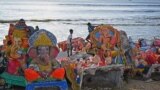 Boys stand next to the remains of idols of the Hindu deity Ganesha after they were immersed by devotees in the Bay of Bengal during the Ganesh Chaturthi festival in Chennai, India.