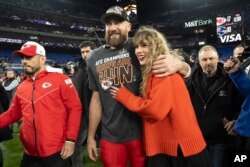 Atlet football NFL, Travis Kelce dari tim Kansas City Chiefs (kiri) dan Taylor Swift (kanan) usai pertandingan Kansas City Chiefs melawan tim Baltimore Ravens di Baltimore, Maryland (dok: AP/Julio Cortez)